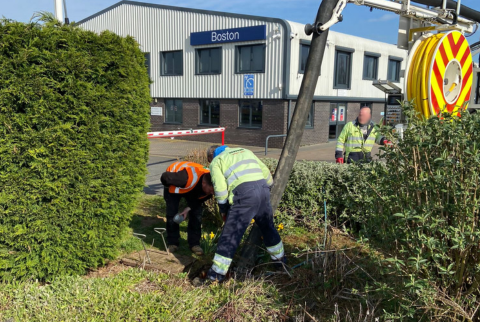 two field engineers clearing a drain using a tanker next to an office building