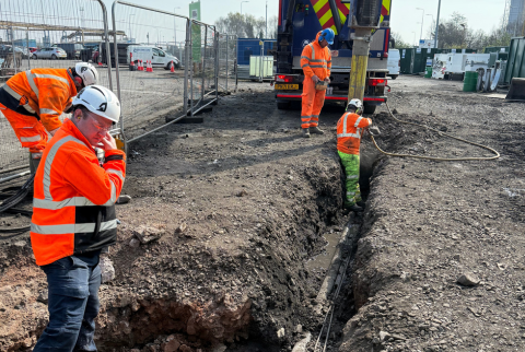 four field engineers creating a new drainage channel using a wet vac machine